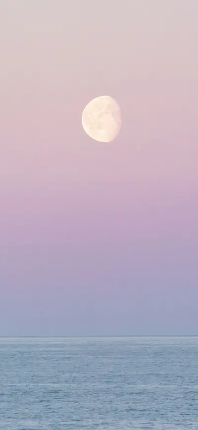 dreamy pastel pink moon over ocean