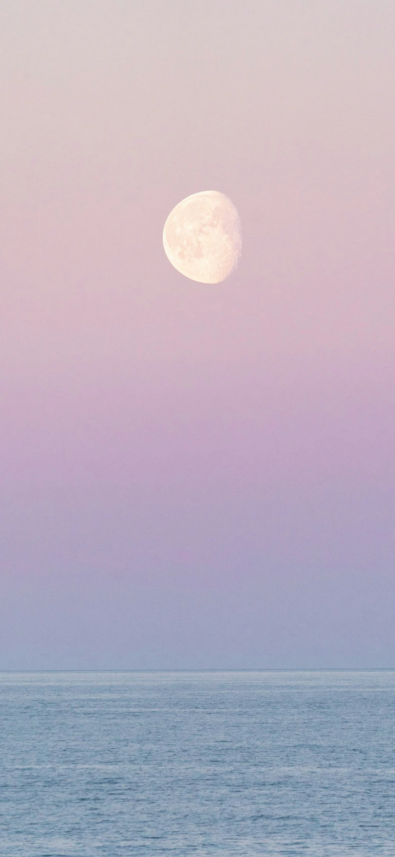 dreamy pastel pink moon over ocean
