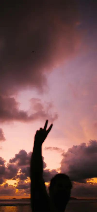 silhouette peace sign golden sunset clouds